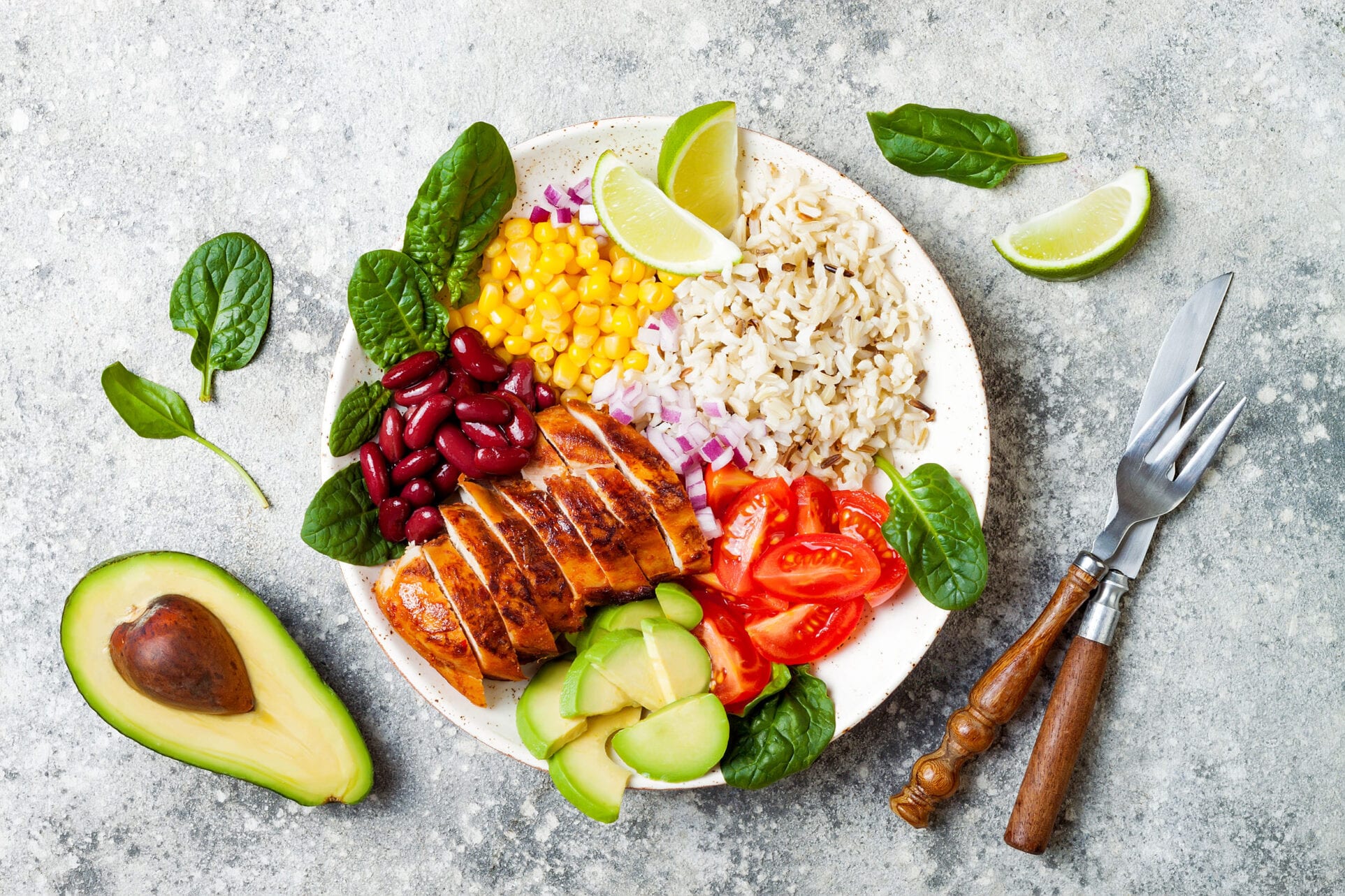 Homemade Mexican chicken burrito bowl with rice, beans, corn, tomato, avocado, spinach. Taco salad lunch bowl
